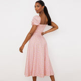 back view of a woman in a pink floral midi dress with puff sleeves