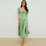 front view of a woman in a green floral midi dress with puff sleeves and a square neckline