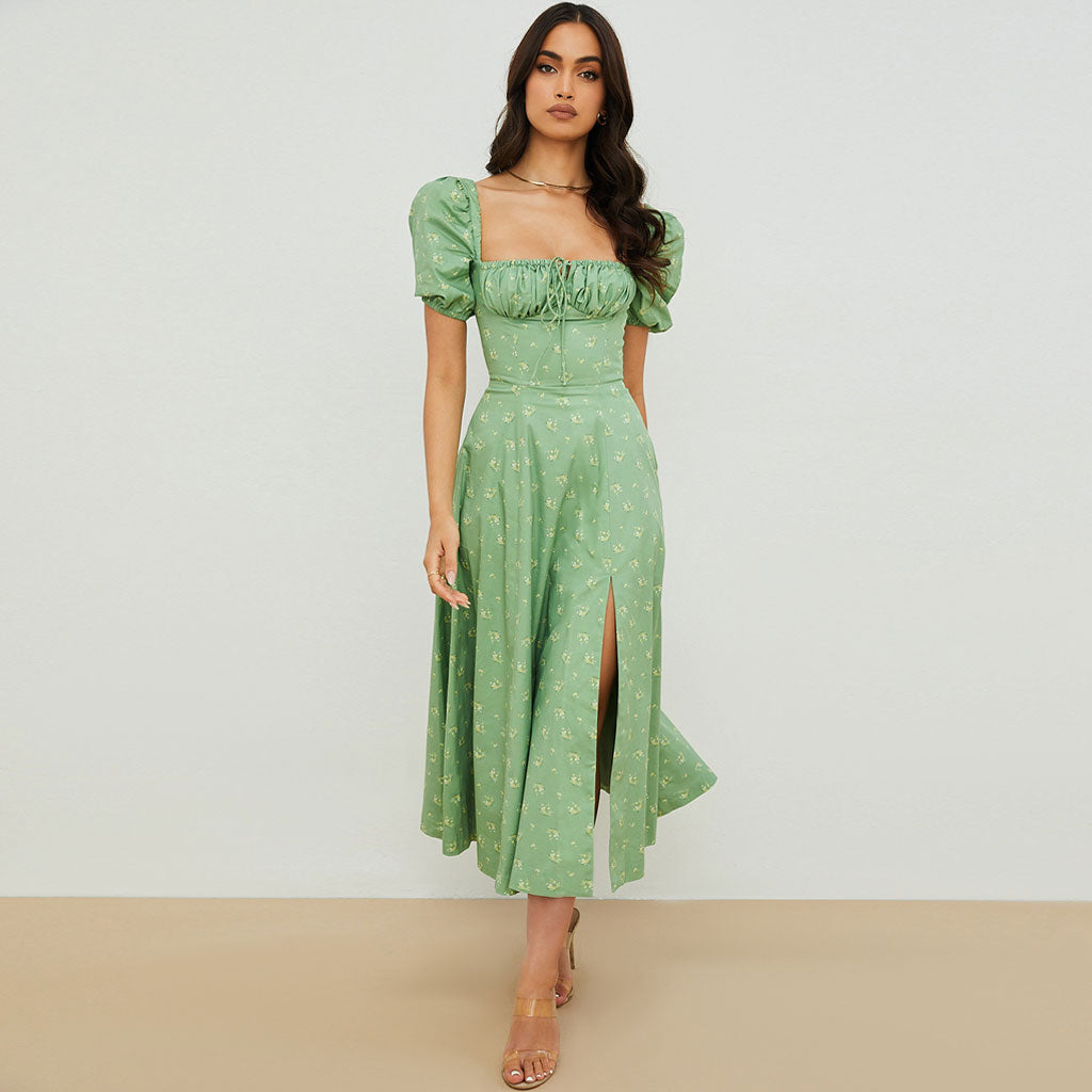 front view of a woman in a green floral midi dress with puff sleeves and a square neckline