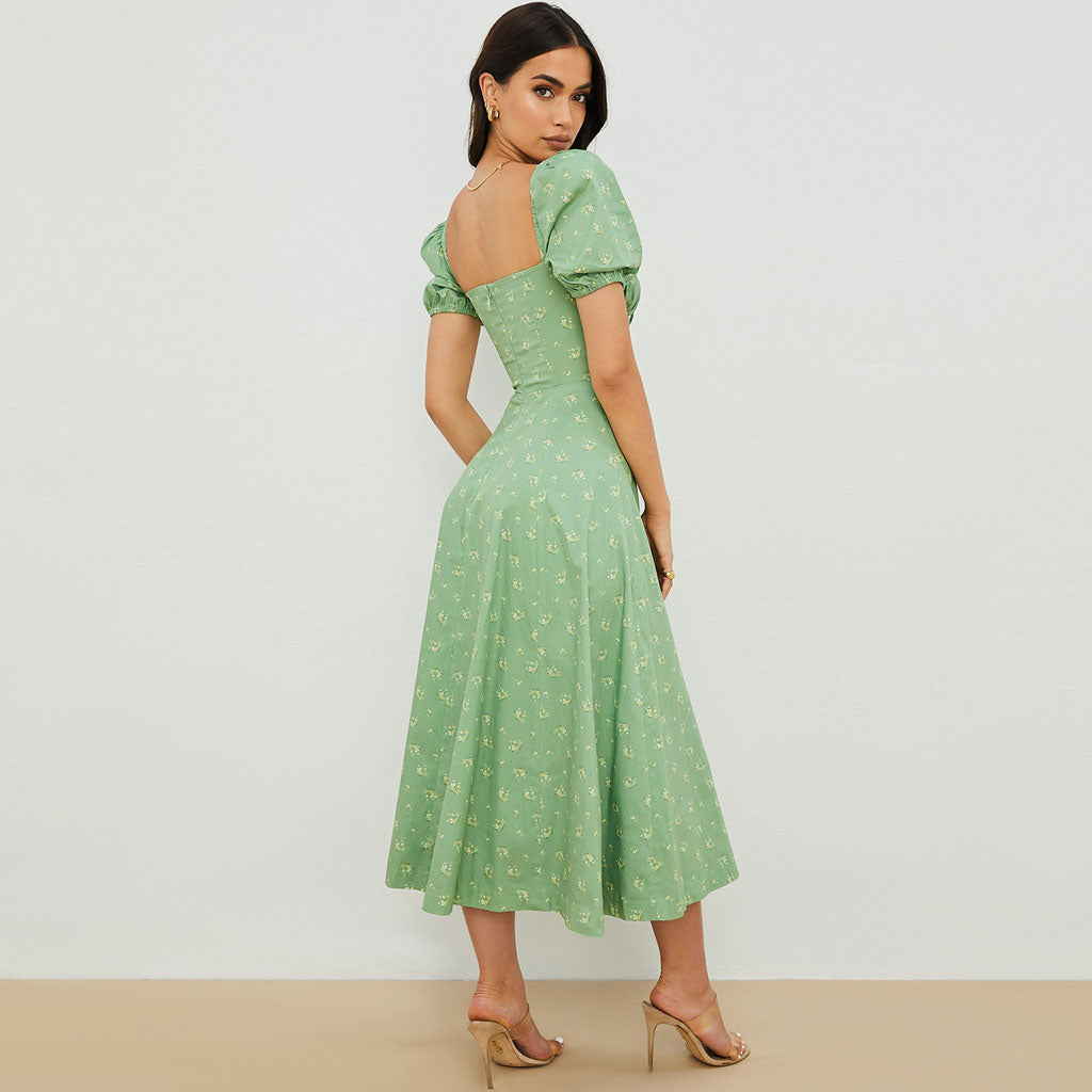 back view of a woman wearing a green floral midi dress with puff sleeves