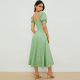 back view of a woman wearing a green floral midi dress with puff sleeves