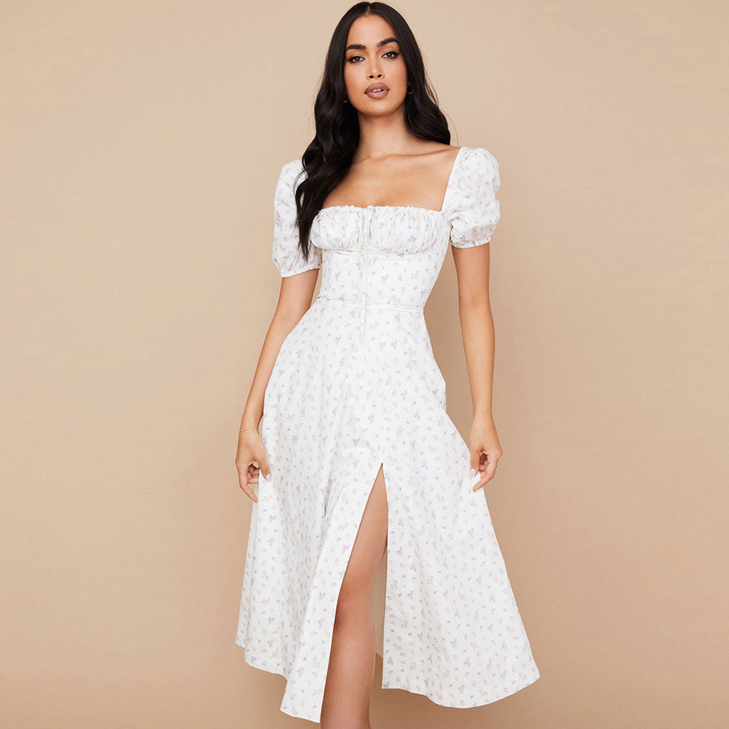 Woman wearing a white floral print midi dress with puff sleeves and a square neckline