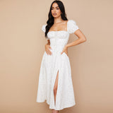 Woman in a white floral midi dress with a high slit and ruched bodice