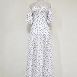 Mannequin displaying a white floral print maxi dress with off-the-shoulder sleeves and halter neckline