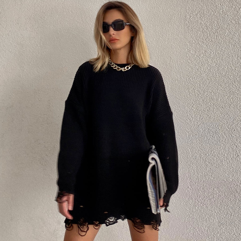 woman in black distressed knit sweater dress with sunglasses and necklace