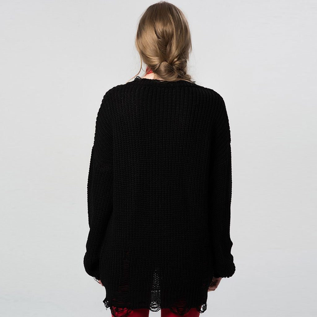 back view of a woman in a black distressed knit sweater dress