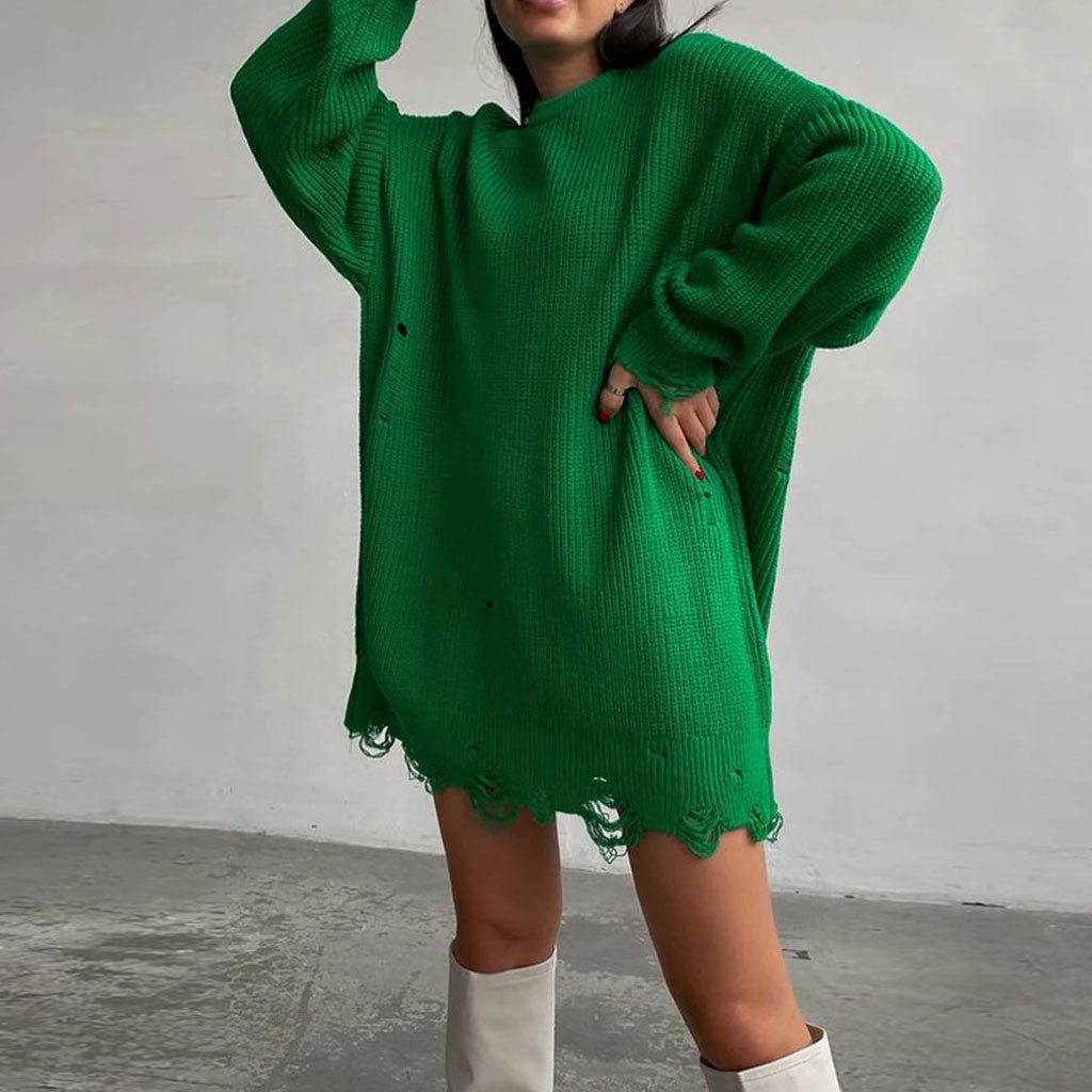 Woman wearing a green distressed oversized knit tunic sweater with white boots