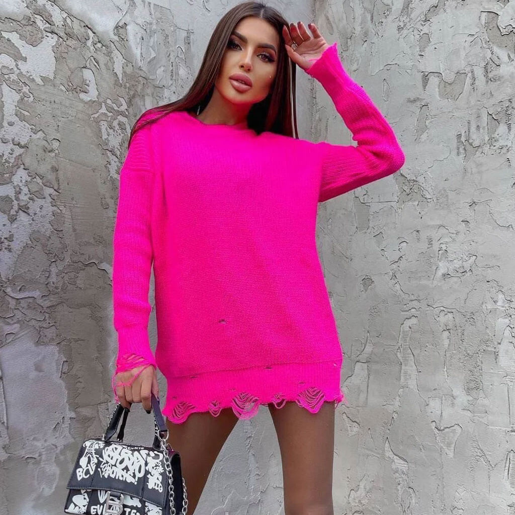 Woman wearing a bright pink oversized distressed knit sweater dress