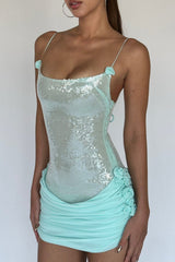 Close-up of the side of a light blue sequined mini dress with ruched skirt and floral accents