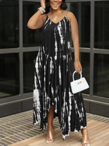 Woman in a black and white tie-dye maxi dress, holding a white handbag.