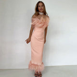 woman wearing a pale pink strapless midi dress with feather trim at the neckline and hem