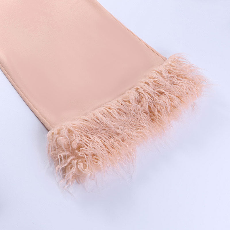 close-up of the feather trim at the hem of a pale pink dress