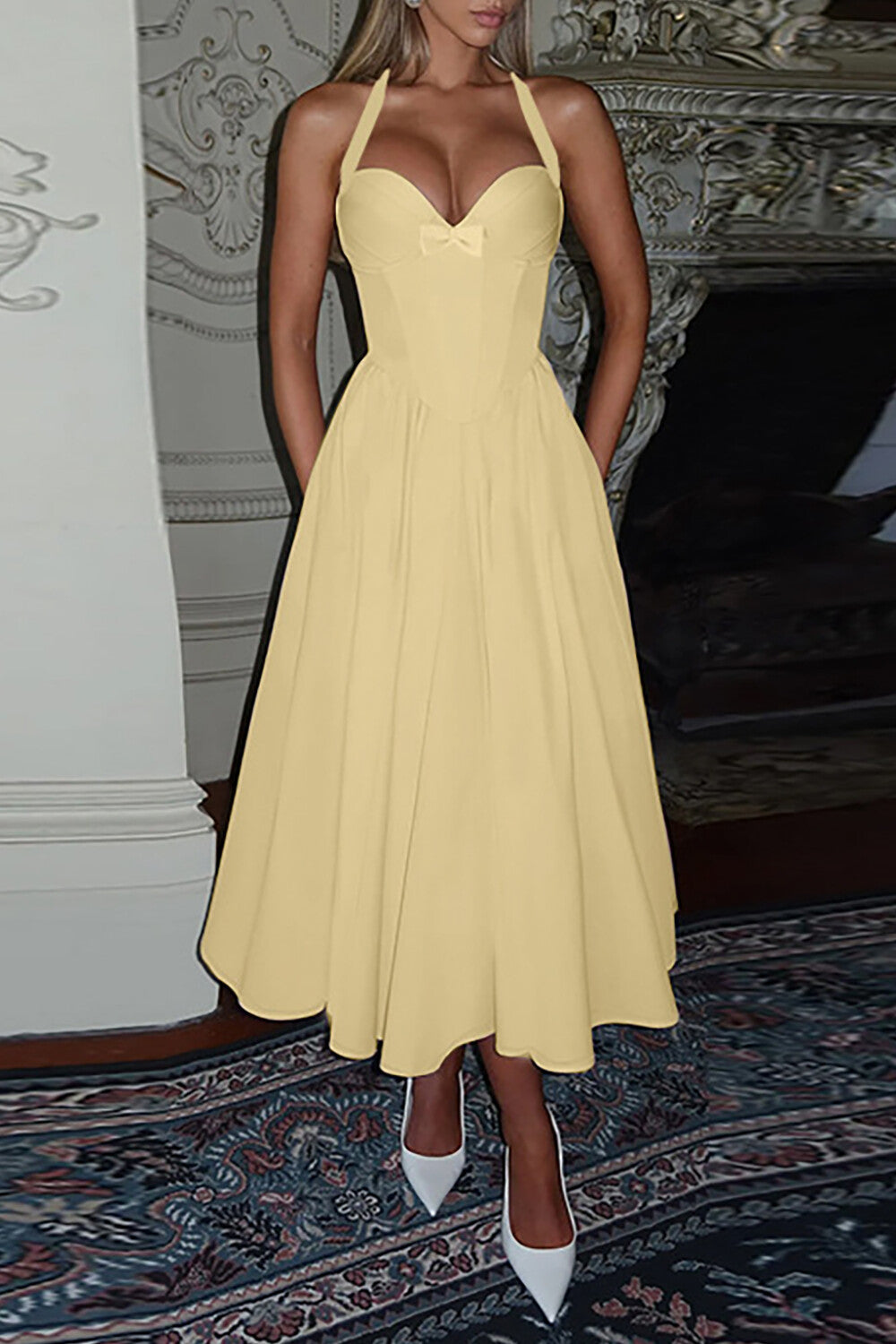 Woman wearing a pale yellow halter midi dress with a fitted bodice and full skirt.