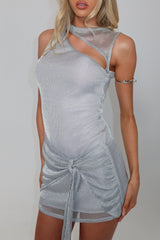 model wearing a silver metallic knit asymmetrical neckline mini dress with a cut-out detail and ruched skirt
