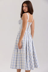 Back view of a woman wearing a blue and white gingham check midi dress with corset lacing.