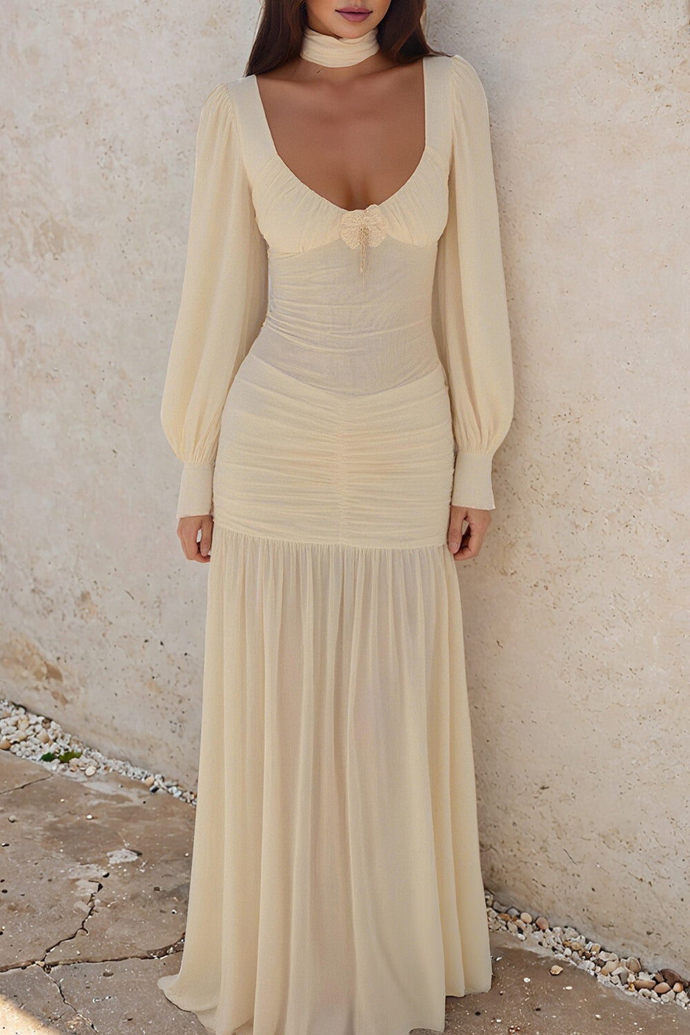 woman in a cream long sleeve ruched dress with a sweetheart neckline and choker