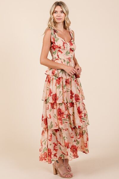 Side view of a woman in a blush pink floral print tiered maxi dress