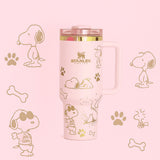 Stanley 40oz insulated tumbler featuring Snoopy illustrations, blue paw prints and bone icons, white body with white ergonomic handle