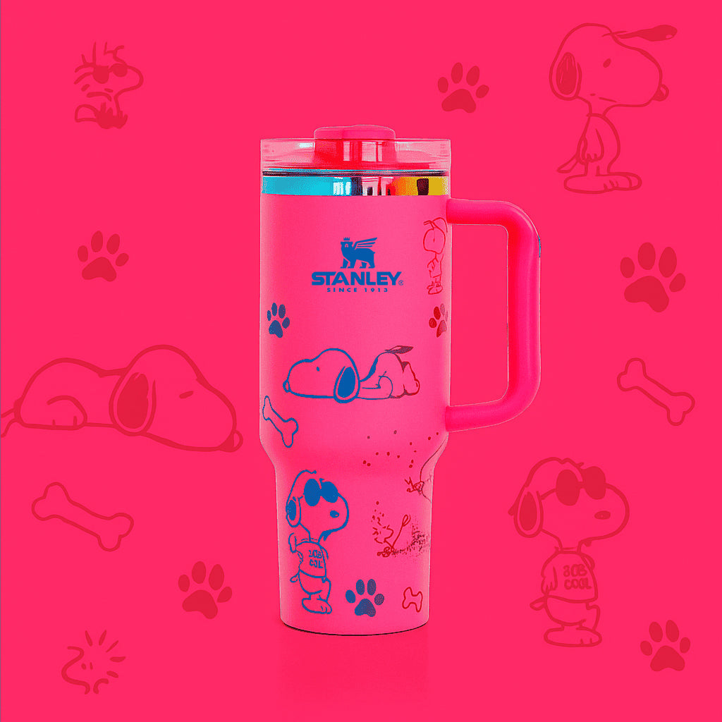 Stanley 40oz insulated tumbler featuring Snoopy illustrations, blue paw prints and bone icons, white body with white ergonomic handle