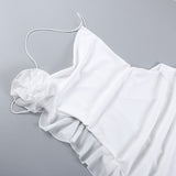 Detail of a white mini dress fabric with floral embellishment and ruffled hem