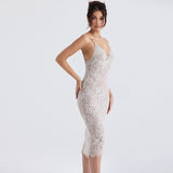 Back view of a woman in a white lace midi dress with an open back