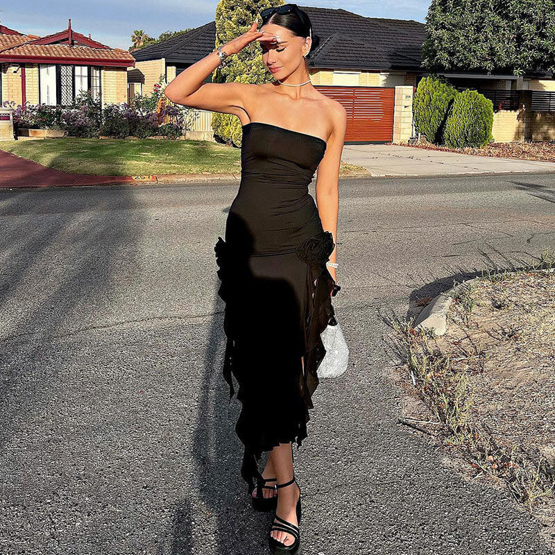 woman wearing a black strapless midi dress with ruffled hem and high slit