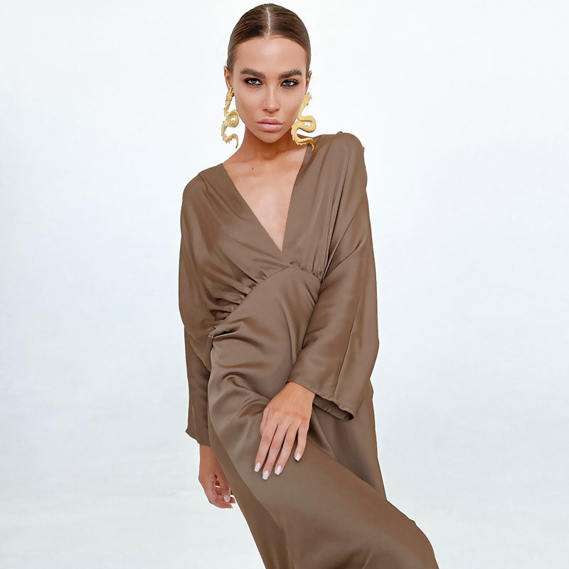 Model wearing a brown satin dress with a deep V-neckline and dolman sleeves.