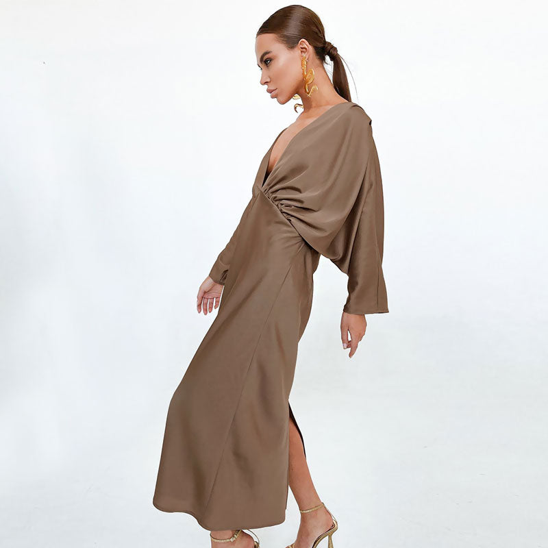 Full-length shot of a model in a brown satin dress with a high slit.