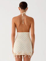 Back view of a woman wearing a cream crocheted halter dress
