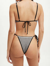 woman wearing a black and white gingham bikini set, back view