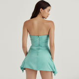 Back view of a woman in a mint green satin strapless ruched mini dress