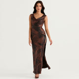 Full length studio shot of a woman in a brown and black abstract print satin maxi dress with a draped cowl neckline and a high slit.