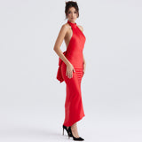 Side view of a woman in a red satin halter dress with a deep open back and a large bow detail.