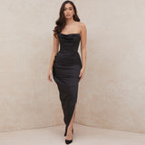 Woman wearing a black strapless satin mermaid dress with a cowl neckline and high slit