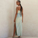 Rear view of a woman in a pale green strapless satin gown with a high slit.
