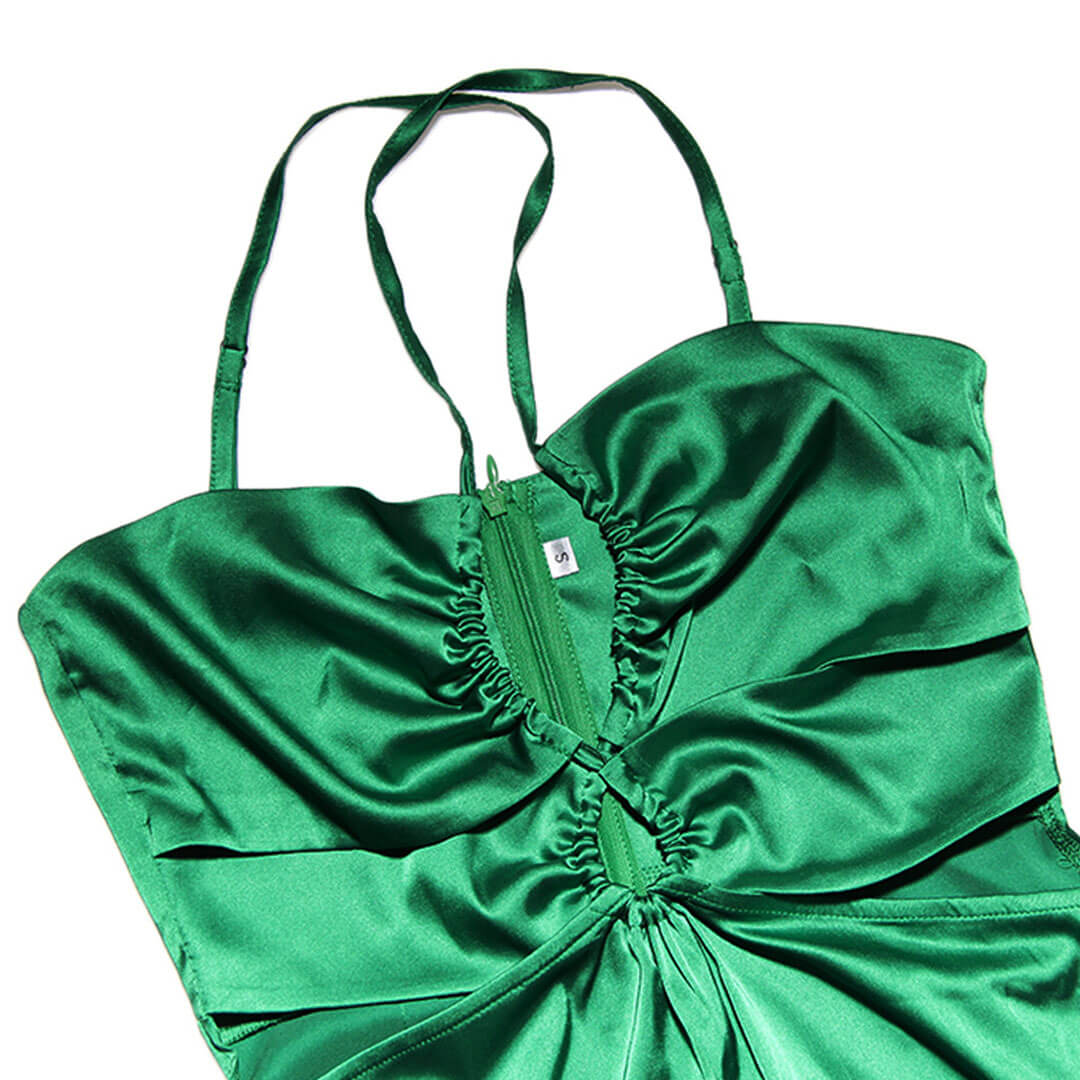 close-up of the bodice of a green satin halter neck maxi dress, showing ruching and a zipper