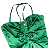 close-up of the bodice of a green satin halter neck maxi dress, showing ruching and a zipper