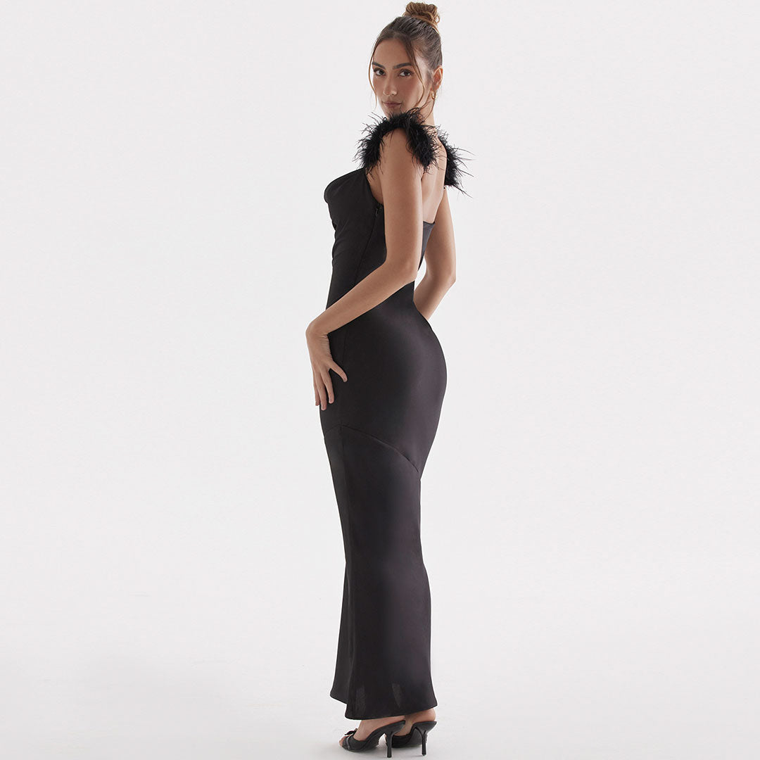 Back view of a woman in a black satin floor-length gown with feather shoulder trim.