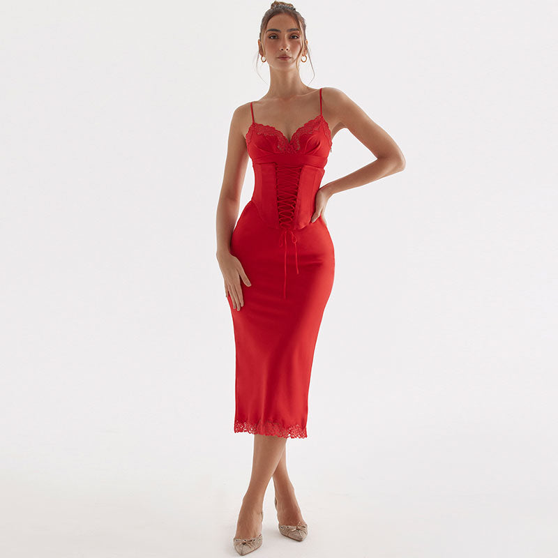 Woman wearing a red satin sheath dress with lace trim and lace-up detail