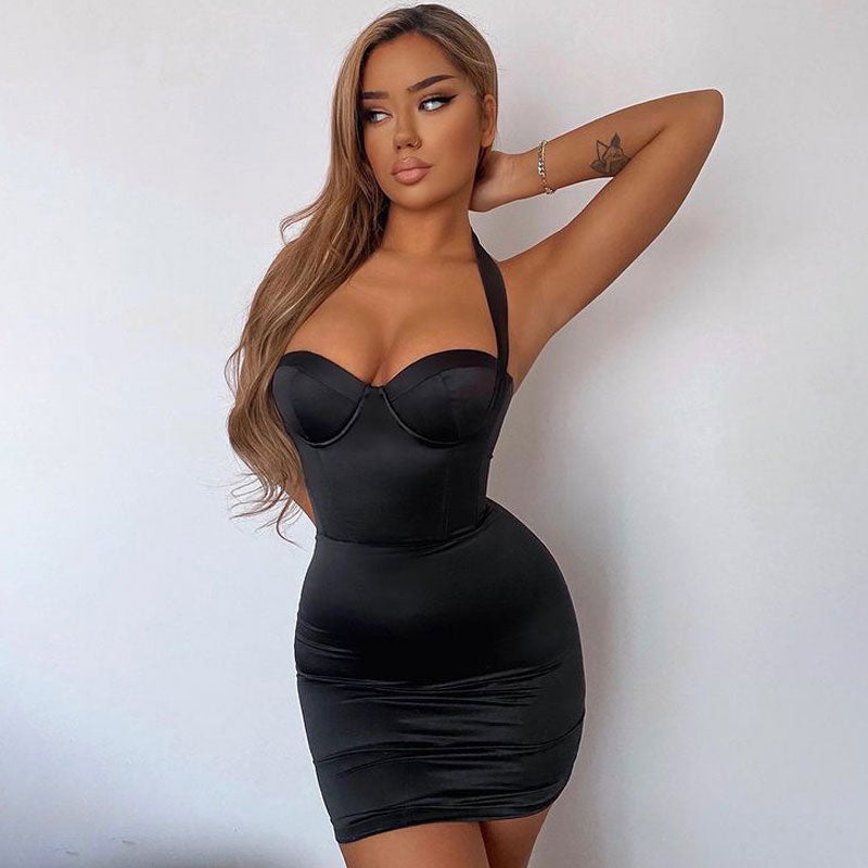 Woman wearing a black satin mini dress with a halter neckline and ruched detailing.