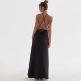 back view of a woman in a black open-back halter dress