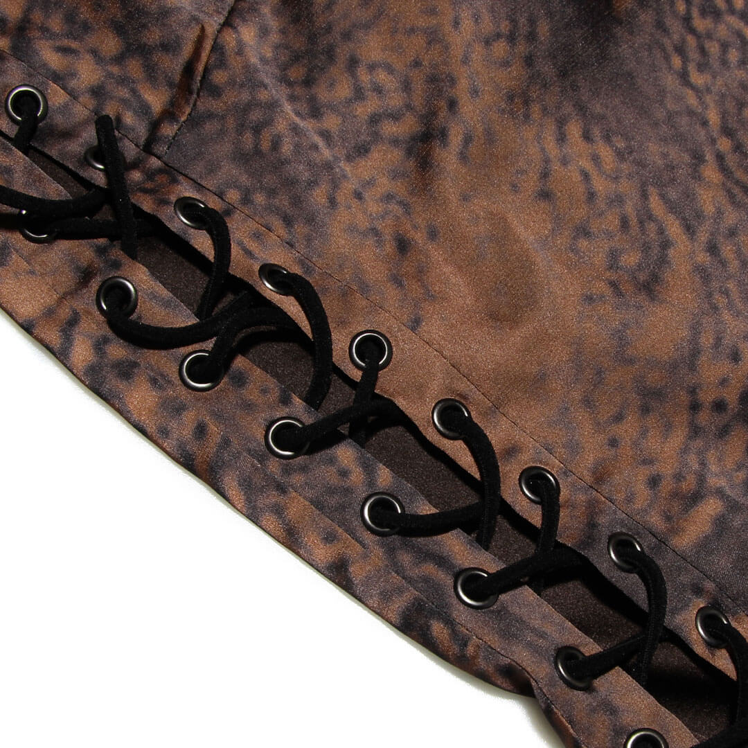 Close-up of the lace-up side detail on a brown printed mini dress.