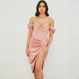 Woman wearing a pink off-the-shoulder satin dress with a corset bodice and a high slit, front view