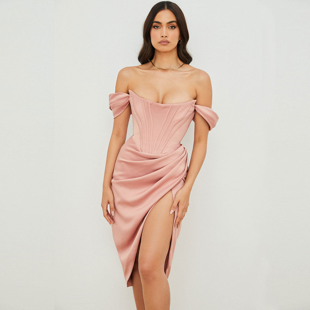 Woman wearing a pink off-the-shoulder satin dress with a corset bodice and a high slit, front view