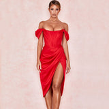 Woman in a red off-the-shoulder satin dress with a corset bodice and high slit, front view.