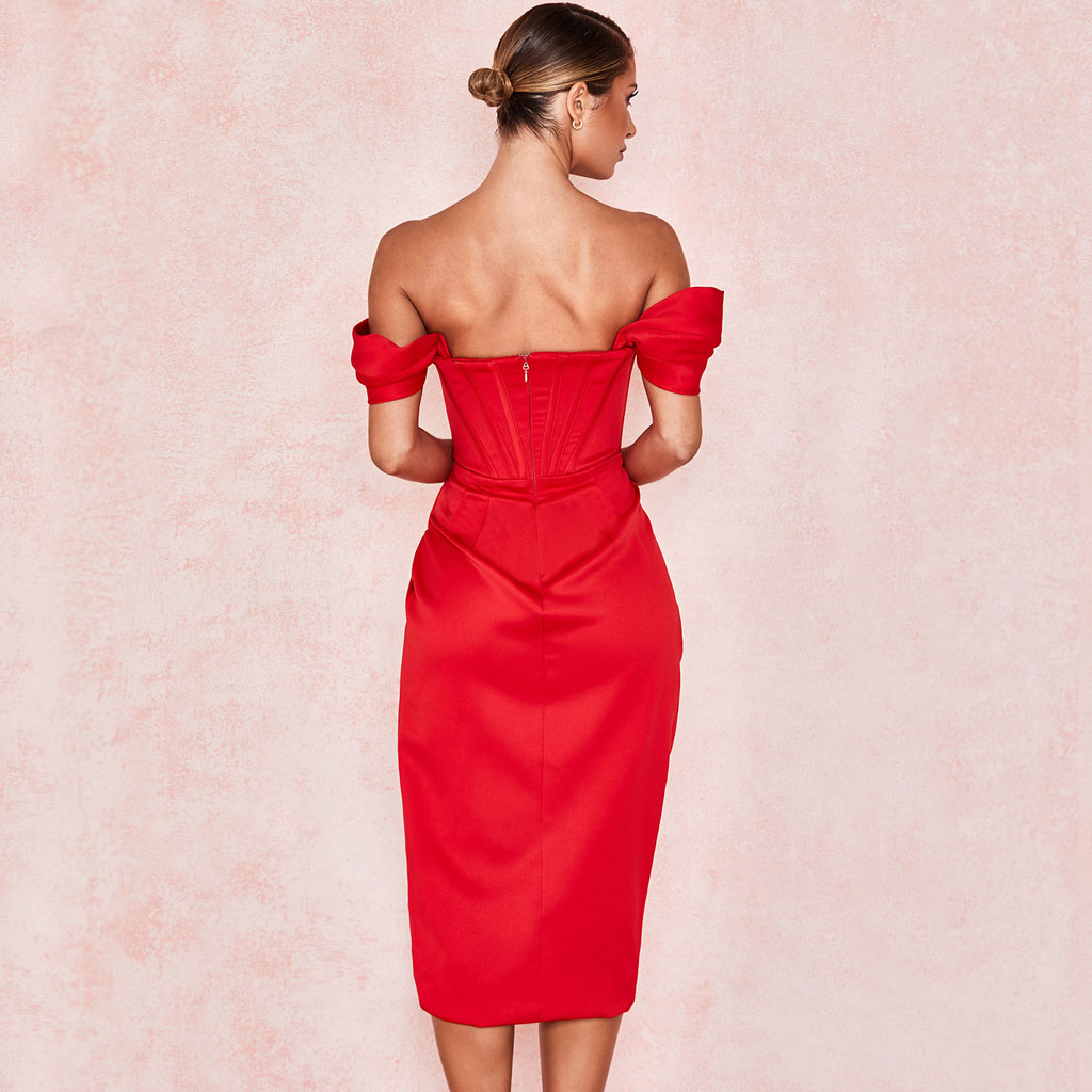 Woman in a red off-the-shoulder satin dress with a corset bodice and high slit, back view.