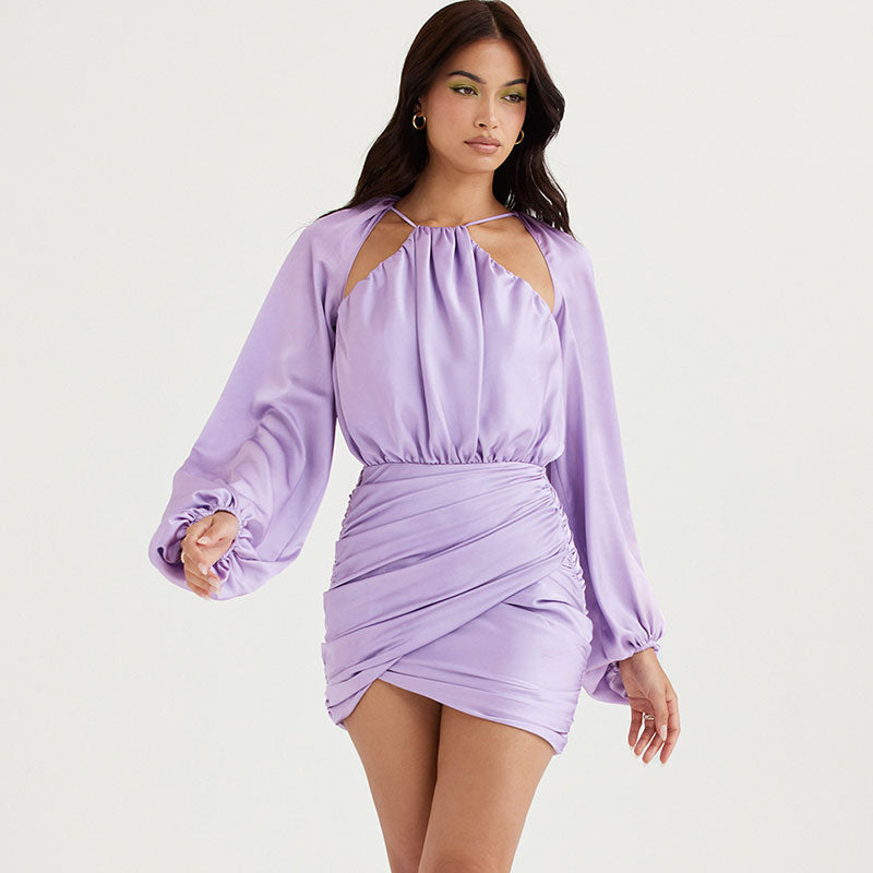 Woman posing in a lavender satin mini dress with long balloon sleeves and ruched detailing.