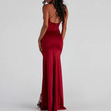 Back view of a woman in a dark red satin formal dress, showcasing the spaghetti straps and a flowing skirt.
