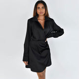 full body shot of a woman in a black satin wrap dress