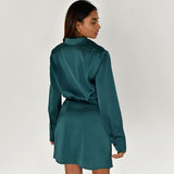 Woman wearing a teal satin long sleeve wrap mini dress from the back